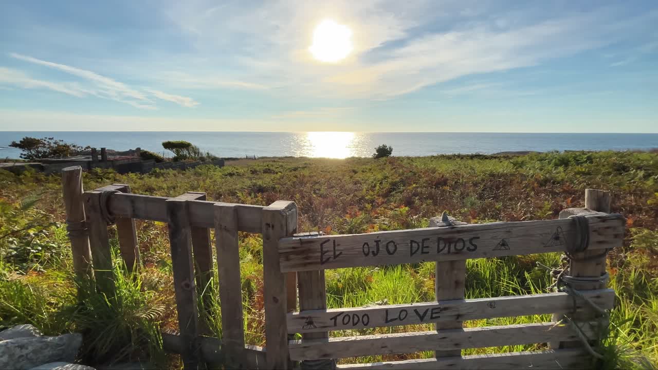 Sunset over the ocean with a wooden gate