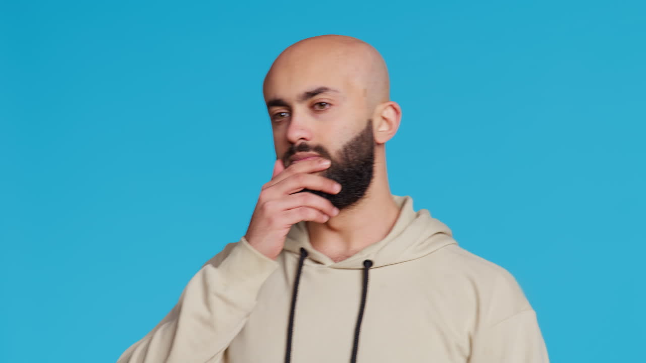 Middle eastern man feeling exhausted and yawning in studio