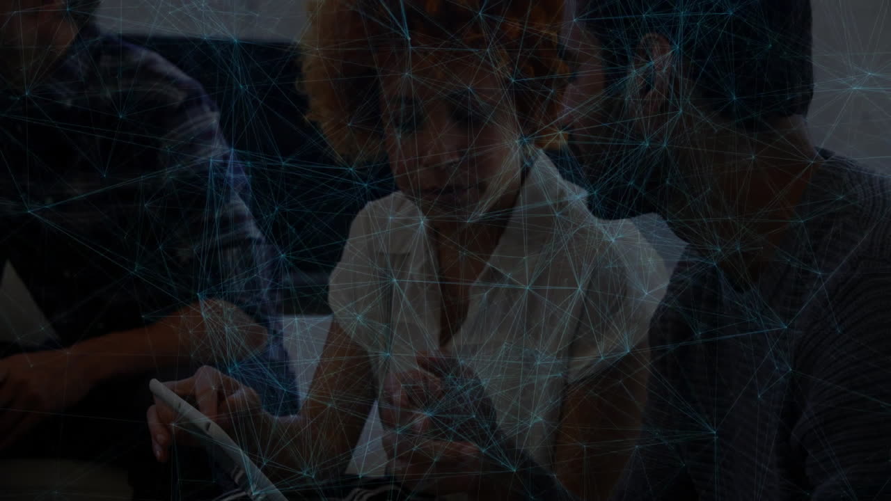 Coworkers leaning around tablet, tapping screen while blue network lines mapping business data flow