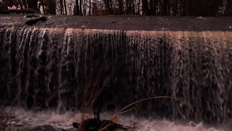 a drone flies along the waterfall at sunset beautiful view