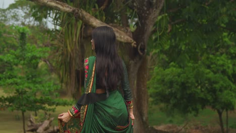 A-young-girl-enjoys-a-sunny-day-at-a-tropical-park-in-the-Caribbean,-dressed-in-traditional-Indian-wear