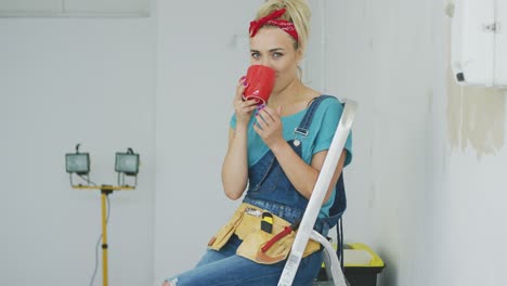 Female-sitting-with-drink-on-stepladder-