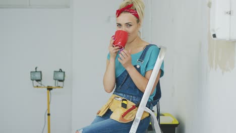 female sitting with drink on stepladder