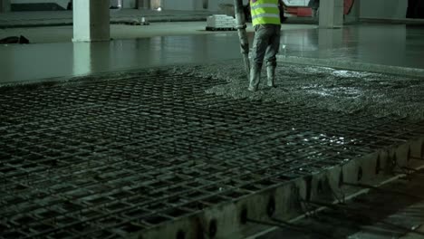 reinforced concrete. worker concretes foundation, rebar, pour cement mortar on reinforcing mesh. builders are building a factory, hangar.