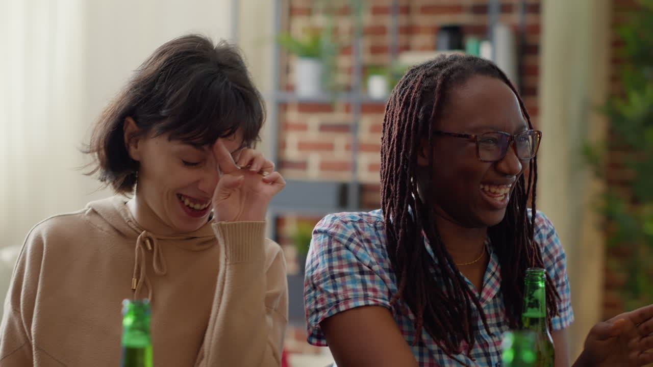Diverse group of friends having fun with beer bottles at home