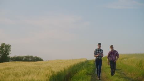 Two Farmers Discuss While Walking in the Countryside