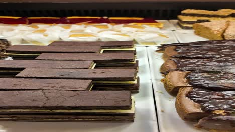 assortment of delicious cakes and pastries in a bakery display case