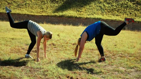 women practicing yoga during obstacle course