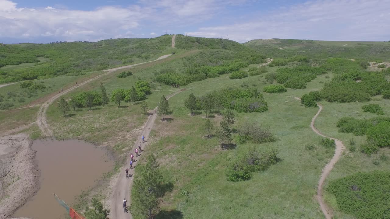 вид с беспилотника на горных велосипедистов, быстро едущих во время гонки