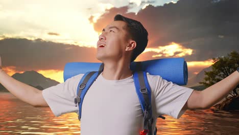 close up of asian male hiker with mountaineering backpack smiling and spreading arms enjoy looking the view around at a lake
