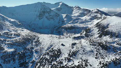 Toma-De-Drones,-Inclinación,-Toma-Amplia-Del-Pico-Musala-Y-Cumbres-Cercanas,-Día-Soleado,-Cielo-Azul-Claro,-Montaña-Rila,-Bulgaria