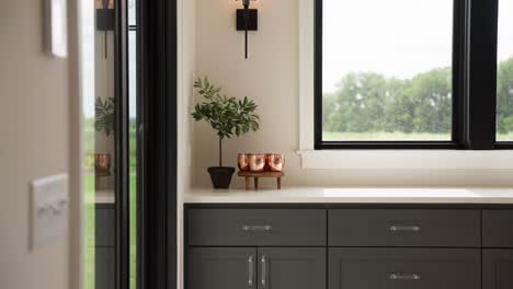 Panning-shot-of-a-white-countertop-bar-with-a-small-green-plant-and-Moscow-Mule-cups