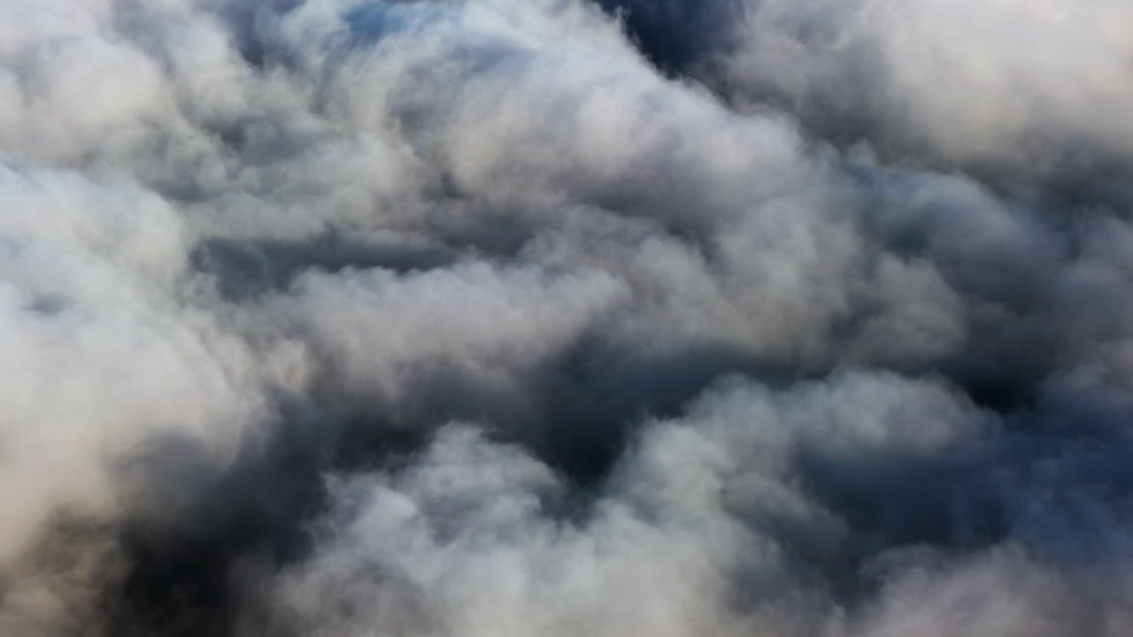 Aerial view of dense white cloud formation from high altitude. Soft atmospheric texture above the horizon during flight