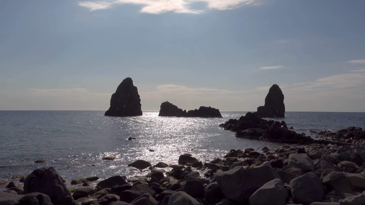 The stone cliffs of Cyclops (Faraglioni dei Ciclopi) near Aci Trezza town, Sicily, Italy in partialy graded Log footage