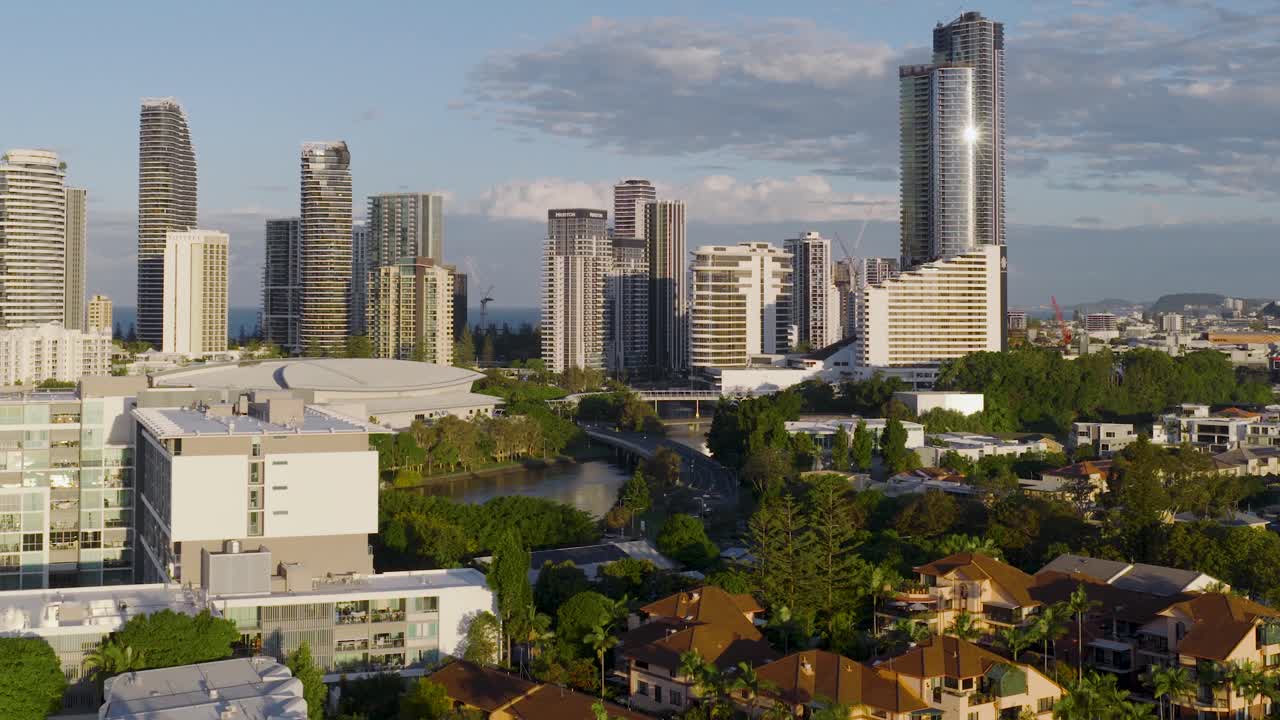 Drone footage captures Gold Coast's skyline and ocean during golden hour, highlighting urban architecture and natural beauty
