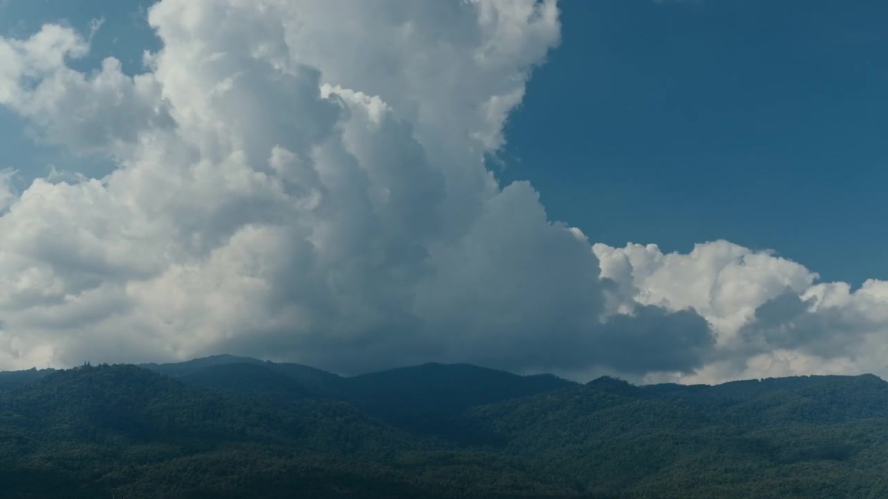 Time Lapse of White Clouds Moving Over Green Mountain Range