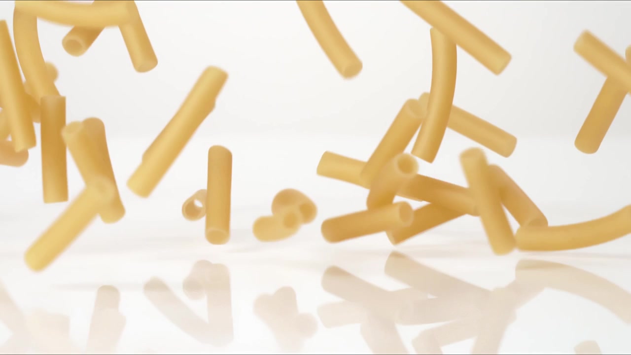 Ziti Canelloni freschi crudi che rimbalzano su un tavolo bianco in slow motion, in un primo piano macro, prima di posarsi