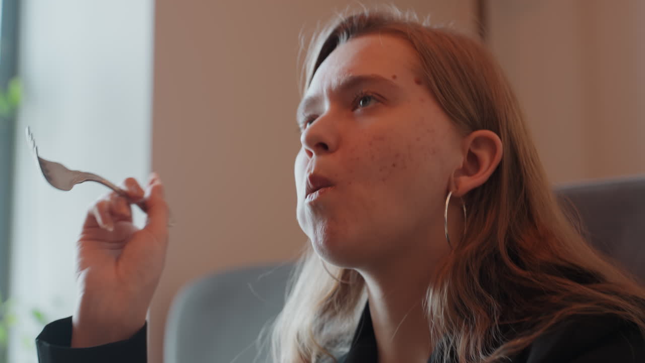 White woman savoring bite, facial closeup, intimate portrait of chewing and expression, hoop earrings catching warm light, freckles and skin texture visible, lips and eyes engaged in taste, slow