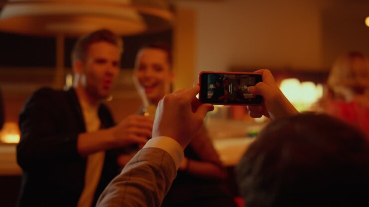 Amici felici in posa con lo smartphone in un bar