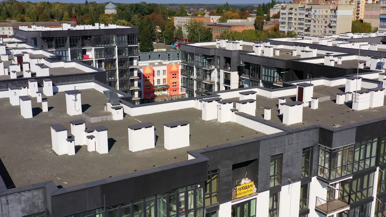 New architecture in the city. High-raise apartment buildings near the road. Modern design of multistorey building. Drone flight.
