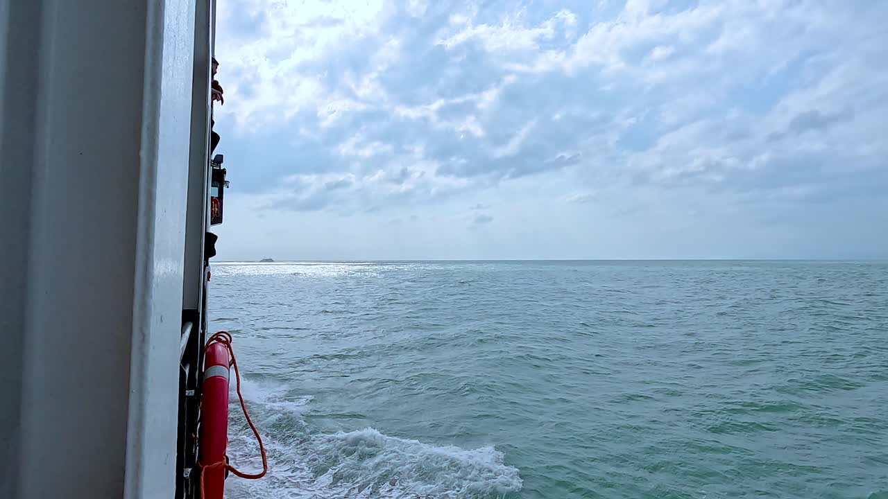 A tranquil ferry ride captures the expansive ocean under a cloudy sky, highlighting the calmness of Koh Samui's waters