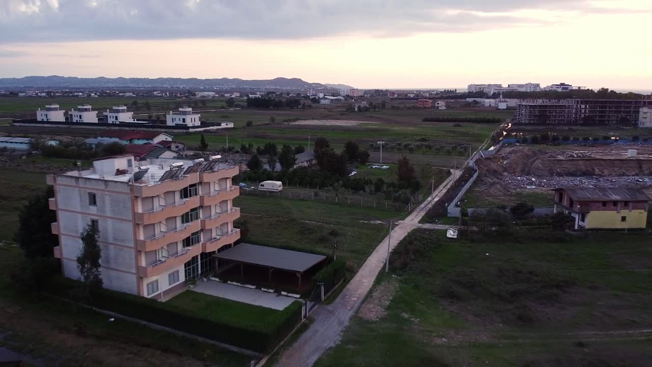 Aerial above Albanian countryside town with hotels and agricultural fields in Golem.
