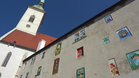 a view looking up at the central cathedral with painted windows and art in central bratislava slovakia