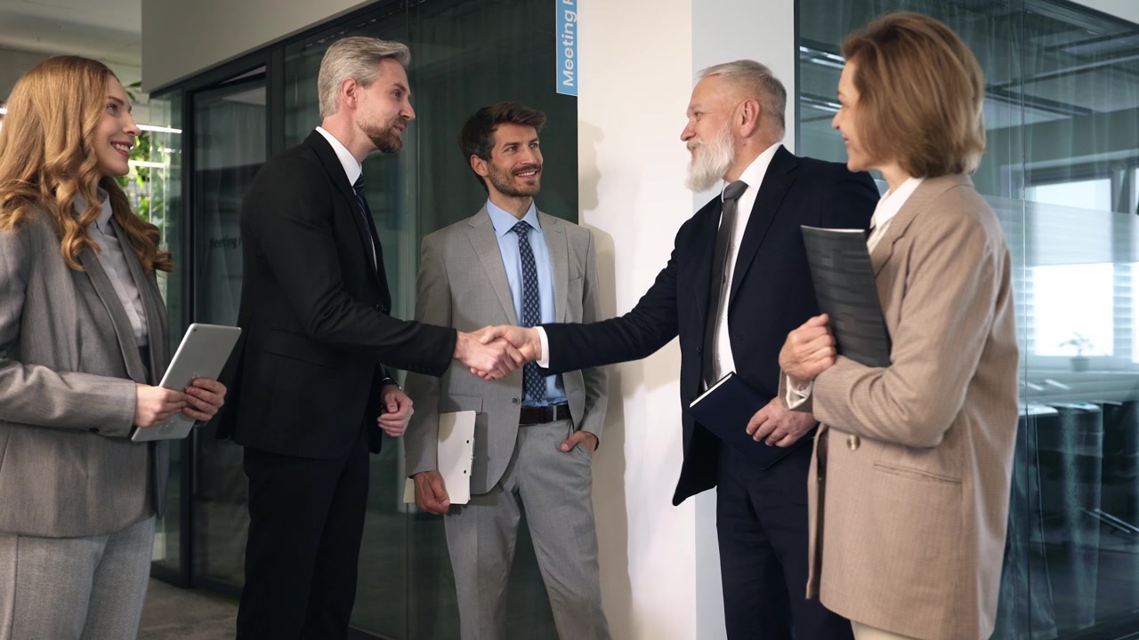 Professionisti d'affari che si stringono la mano in un ufficio moderno