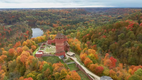 aerial autumn landscape view of the old turaida castle, surrounded by forests colorful bright yellow orange and green trees, sunny day