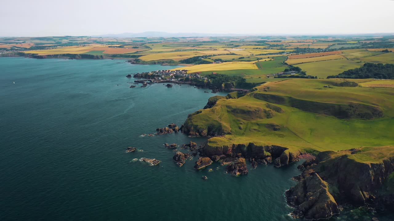 Hovering Over Scotland’s Coastline: Coastal Village and St Abbs Head’s Cliffs Aerial Wonders. Scenic and Rugged Coastline, Scotland, United Kingdom.