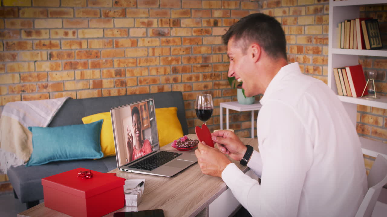 발렌타인 데이트 비디오 통화에서 다양한 커플 노트북 화면에서 여자 손을 흔드는 남자 심장을 들고