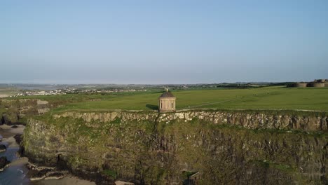 Vista-Aérea-Del-Templo-De-Mussenden-En-La-Cima-Del-Acantilado-Sobre-La-Costa-De-Irlanda-Del-Norte-En-Un-Día-Soleado