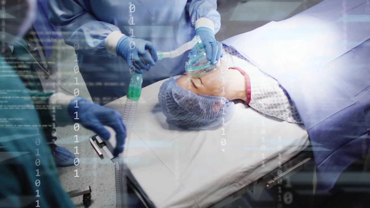 Video verticale: Dottore che posiziona maschera e tubo, preparando la sedazione, con scansione in sovrapposizione sul paziente in sala operatoria.