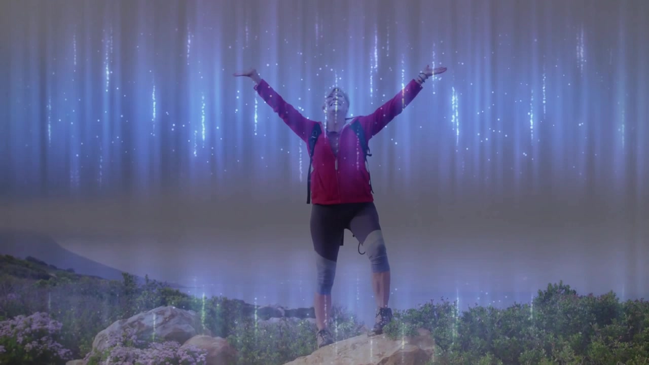 Mujer excursionista contemplando estelas luminiscentes, levantando los brazos sobre la cresta abrazando la luz por salud