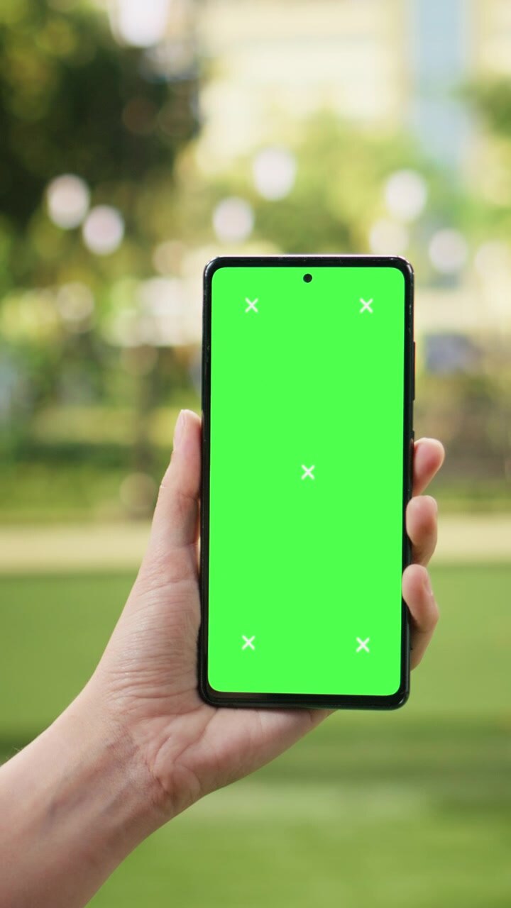Video verticale: mockup di smartphone con chroma key in mano a una donna all'aperto