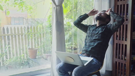 man relaxing and stressed at home office