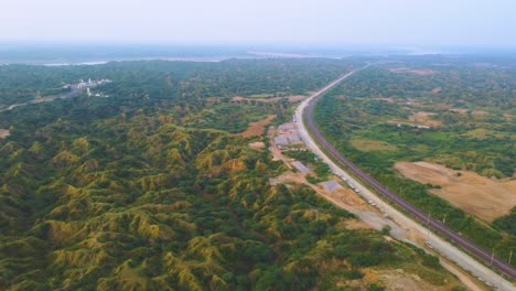 tomada aérea de un avión no tripulado de una vía férrea vacía a través del valle de bosque semiárido del río chamber en la india