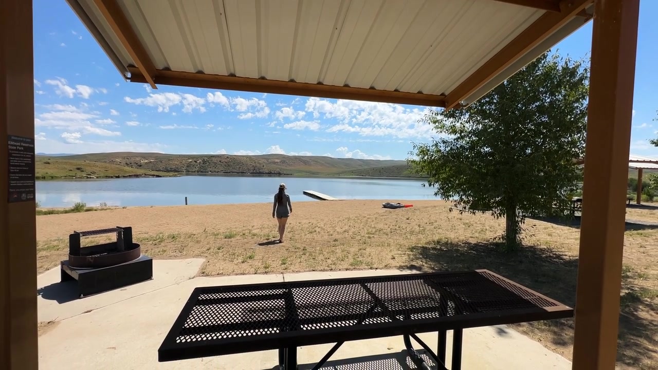 Kvinde går på sand og strand ved Elk Water Reservoir, Nordvest Colorado USA på en solskinsdag.