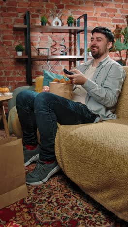 man eating fried chicken on the couch