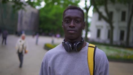 Close-Up-Portrait-Of-Handsome-Young-Man-Smiling-Cheerful-At-Camera-Enjoying-Calm-Urban-Evening-In-City-Commuting-Travel-Lifestyle