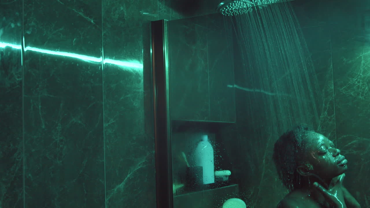 mujer afroamericana duchándose en el baño