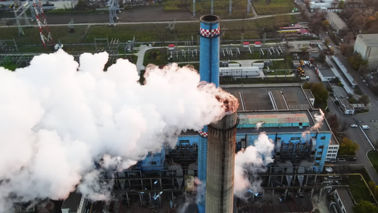 Power station with a lot of tubes and facilities in Bucharest at sunset, a lot of foam from inside a tube. View from the drone, Romania