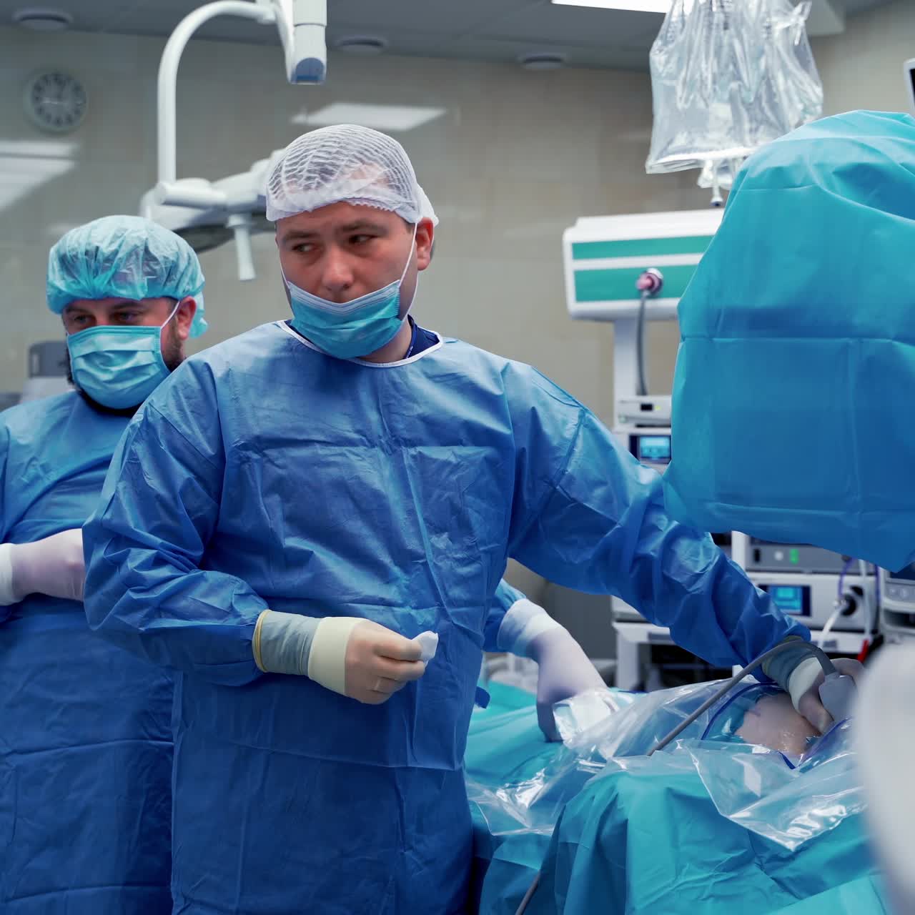 Doctor provides ultrasound check in surgery room. Selective focus of process. Doctor on front view. Video