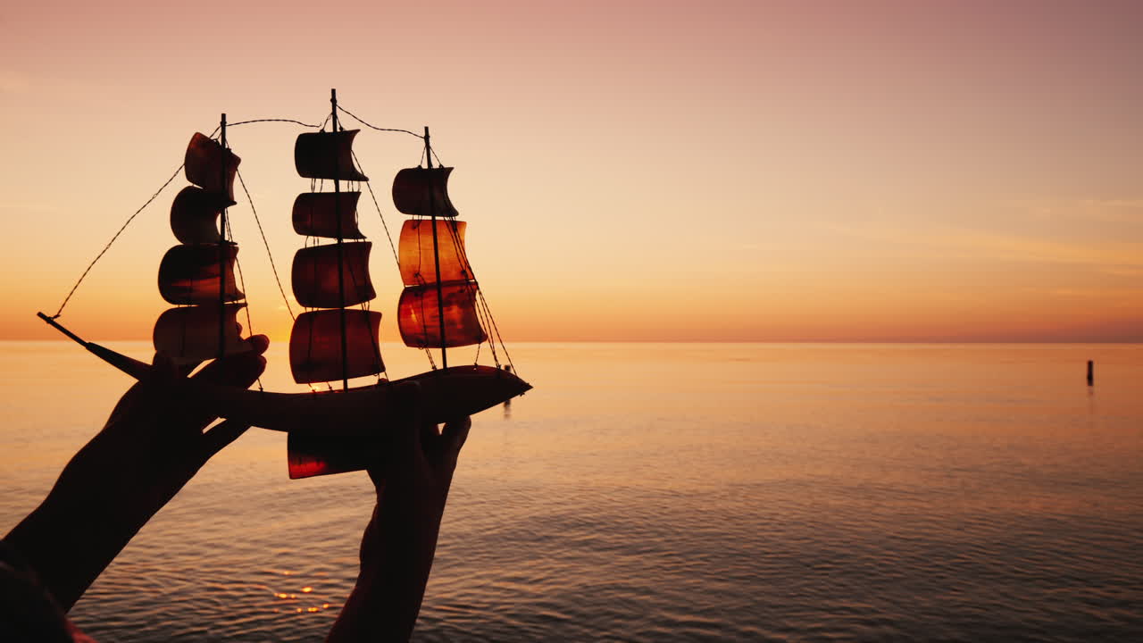 el hombre sostiene un velero de juguete sobre un fondo del concepto de viaje y descubrimiento del mar