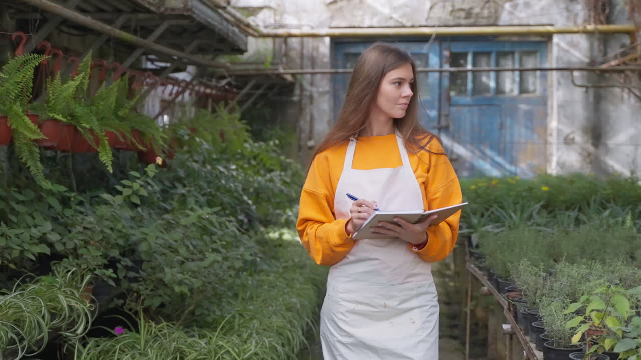 mujer tomando notas en un invernadero