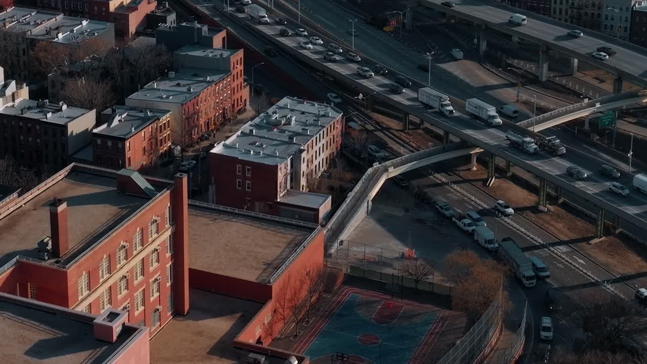 Daytime sports are played in a NYC park near buildings