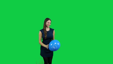 girl playing with the balloon in front of a green screen