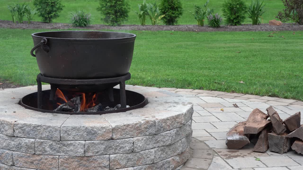 una antigua tetera de hierro sobre el fuego de una fogata al aire libre