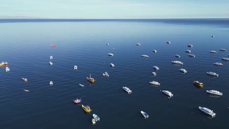 flyover tour boats moored on deep blue water of lake titicaca, bolivia