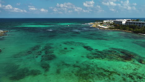 aerial view rising over sunbeds and people on a beach in sunny tulum, mexico
